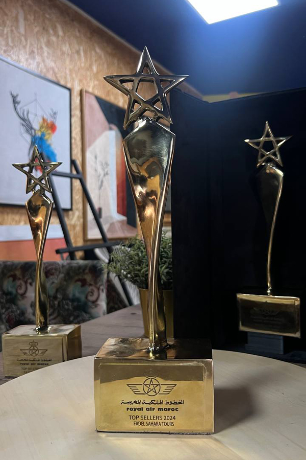 Trois trophées personnalisés à finition dorée avec étoile à cinq branches, dont un trophée Royal Air Maroc Top Sellers 2024 sur socle gravé