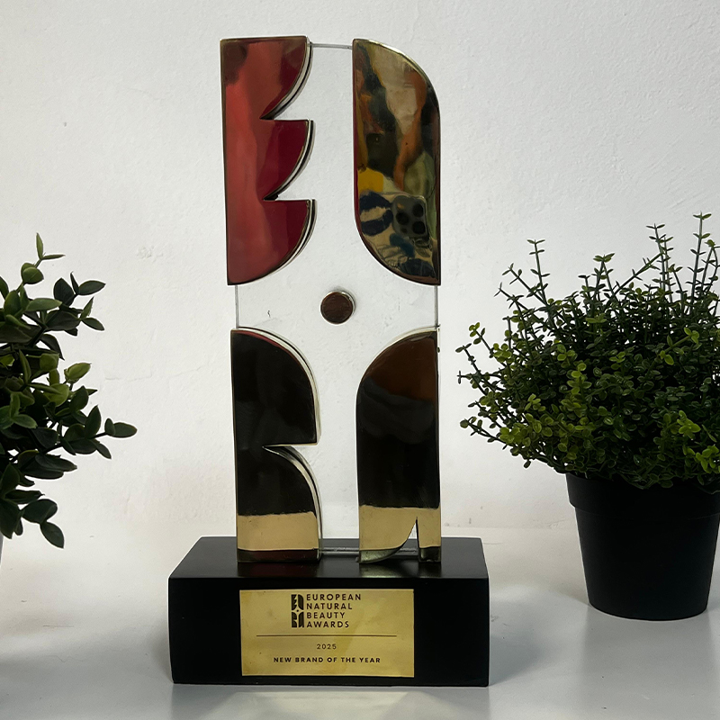 Trophée European Natural Beauty Awards 2025 en laiton et verre avec éléments géométriques aux finitions réfléchissantes et socle noir personnalisé