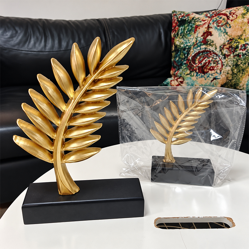 Deux trophées personnalisés en métal effet doré représentant des branches de laurier sculptées, montés sur des socles rectangulaires noirs
