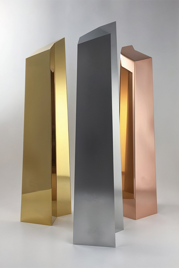 Trois trophées personnalisés au design géométrique vertical avec finitions dorée, argentée et cuivrée, présentés sur fond clair